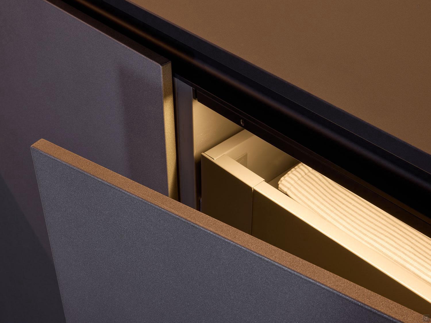 A partially open Modern Kitchens drawer by Kitchen Furniture features a matte finish, illuminated interior, and ribbed dividers—showcasing sleek, minimalist design ideal for custom kitchen spaces.
