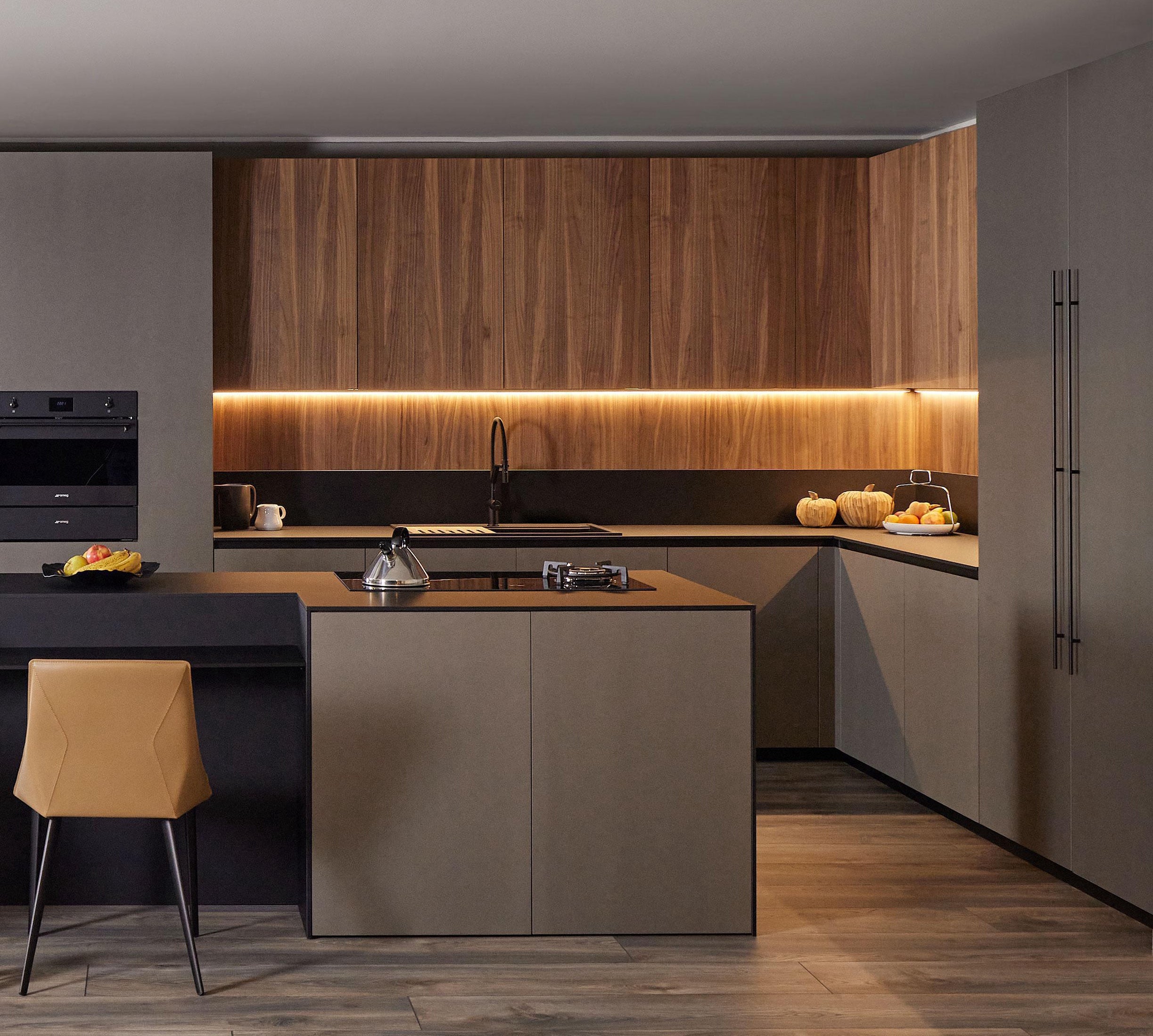 Modern Kitchens by Kitchen Furniture in Yerevan features matte grey cabinets, wood-paneled uppers, under-cabinet lighting, black countertop, built-in appliances, an island with a kettle and fruit, plus custom touches and pumpkins for unique charm.
