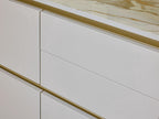 Close-up of Modern Kitchens by Kitchen Furniture, featuring drawers with sleek gold handles and a cream-and-brown marble countertop for an elegant kitchen design.