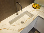 Close-up of a Modern Kitchens sink by Kitchen Furniture, featuring a marble countertop, stainless steel faucet, and a fruit bowl—highlighting elegant design and stylish custom kitchen furniture.