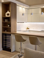 Modern Kitchens by Kitchen Furniture: a Yerevan kitchen with beige cabinets, wooden shelves, custom furniture, built-in wine fridge, two beige bar stools at the counter, stylish pendant lights, and decorative accents.