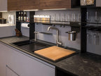 Urban Kitchens by ORDER Kitchen Furniture: a modern countertop with double sink, cutting board, wall-mounted spice rack, hanging wine glasses, knife block, and shelves for bottles—ideal custom furniture for Yerevan urban kitchens.