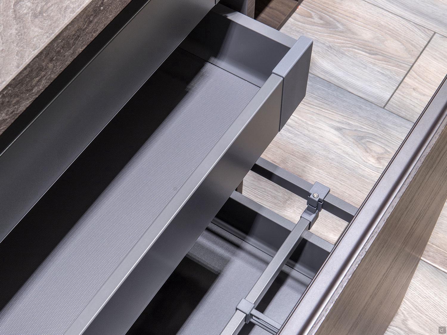 A close-up of a sleek, empty metal drawer by ORDER Kitchen Furniture’s Urban Kitchens collection set against wood-patterned cabinetry—ideal inspiration for custom kitchen design in Yerevan.