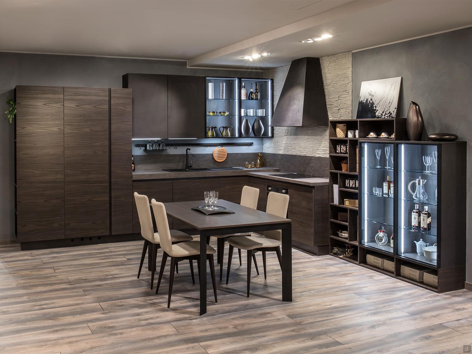 The Urban Kitchens line by ORDER Kitchen Furniture features dark wood cabinets, a custom dining set with four beige chairs, glass-fronted display cabinet, open shelves, light wood flooring, and soft lighting for a cozy atmosphere.