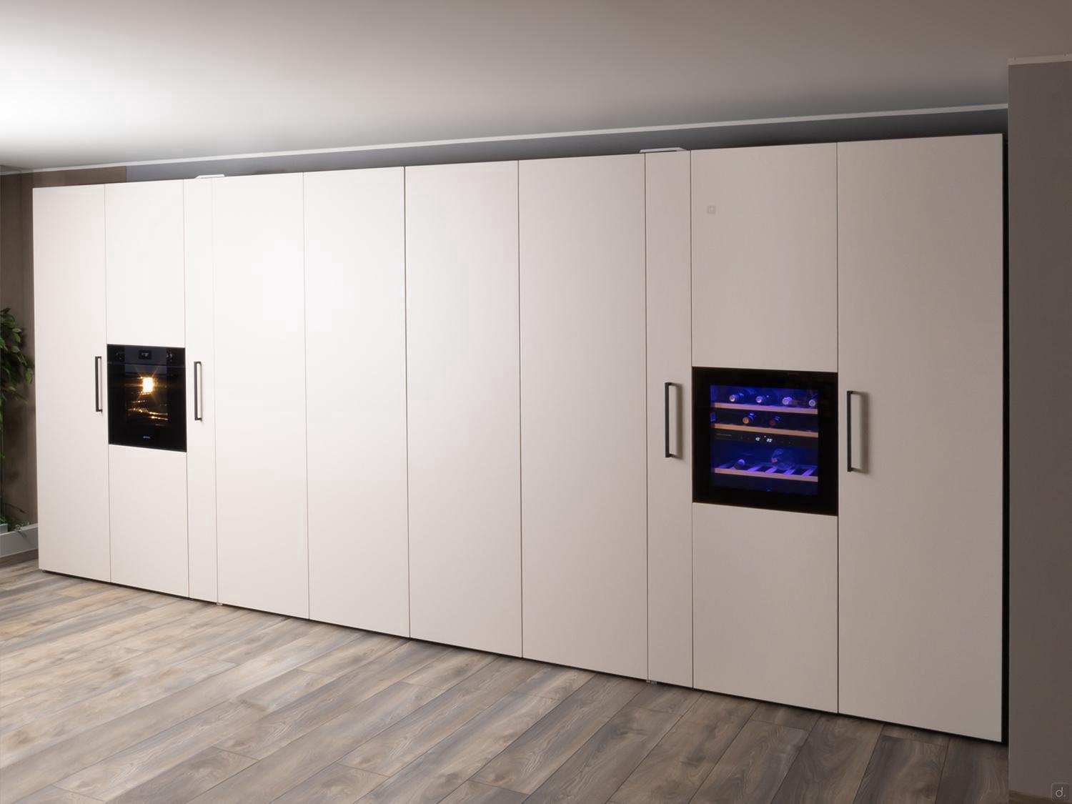 The Urban Kitchens by Kitchen Furniture in Yerevan features large seamless white cabinets with integrated appliances, including a built-in oven and wine cooler with blue lighting, paired with wood-patterned tile flooring for a sleek look.