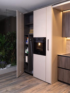 Urban Kitchens by Kitchen Furniture features open tall cabinets for supplies and containers, a built-in oven, wood flooring, and a glassed-in area with green plants—perfect for contemporary Yerevan spaces.