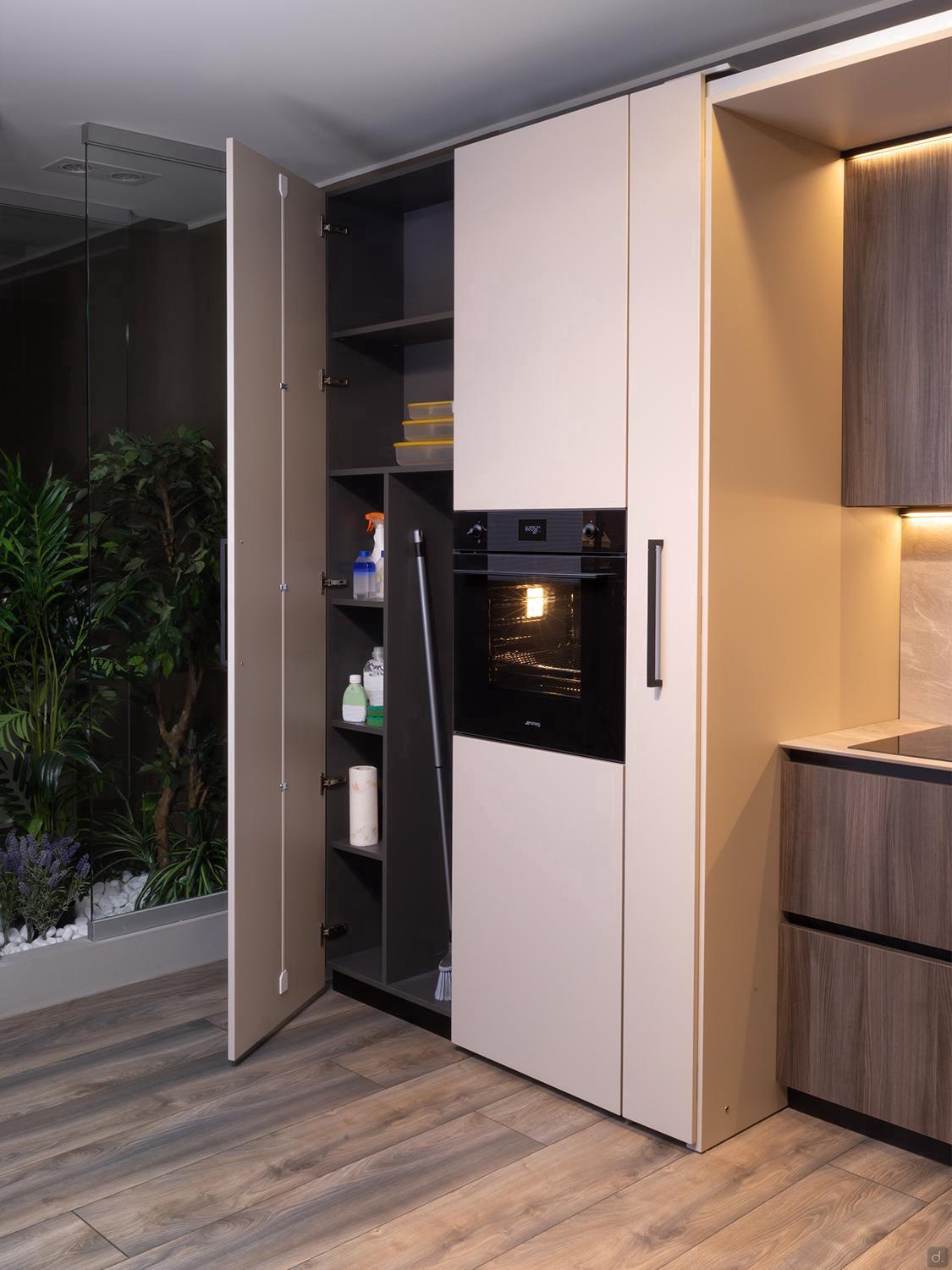 Urban Kitchens by Kitchen Furniture features open tall cabinets for supplies and containers, a built-in oven, wood flooring, and a glassed-in area with green plants—perfect for contemporary Yerevan spaces.